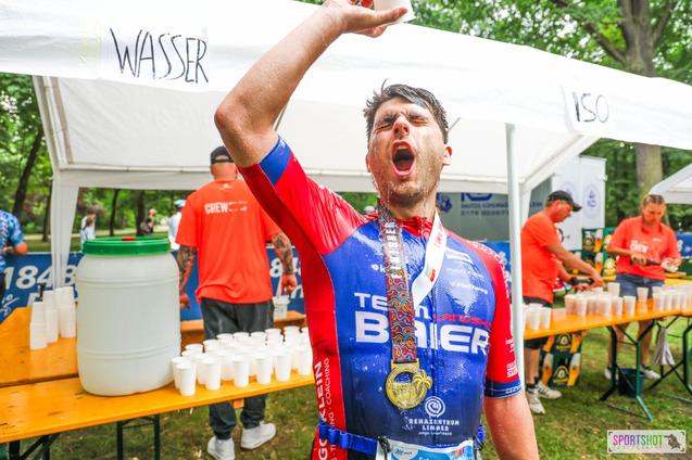 Foto eines Athleten, der sich mit Flüssigkeit aus einem Becher übergießt