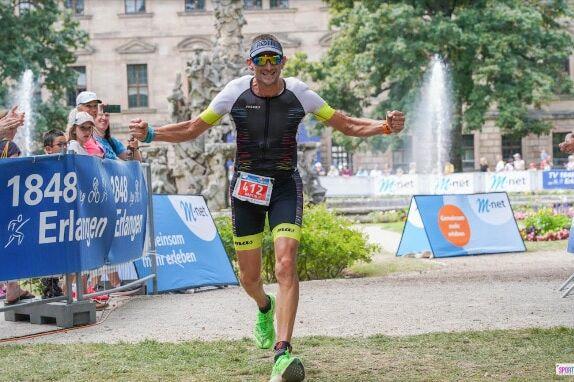 Foto eines Triathlethen beim Zieleinlauf