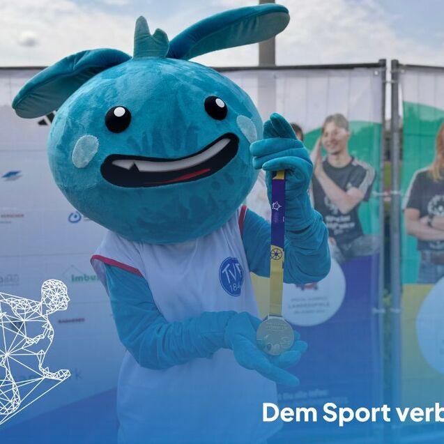 Das Turnerla präsentiert die Goldmedaille.