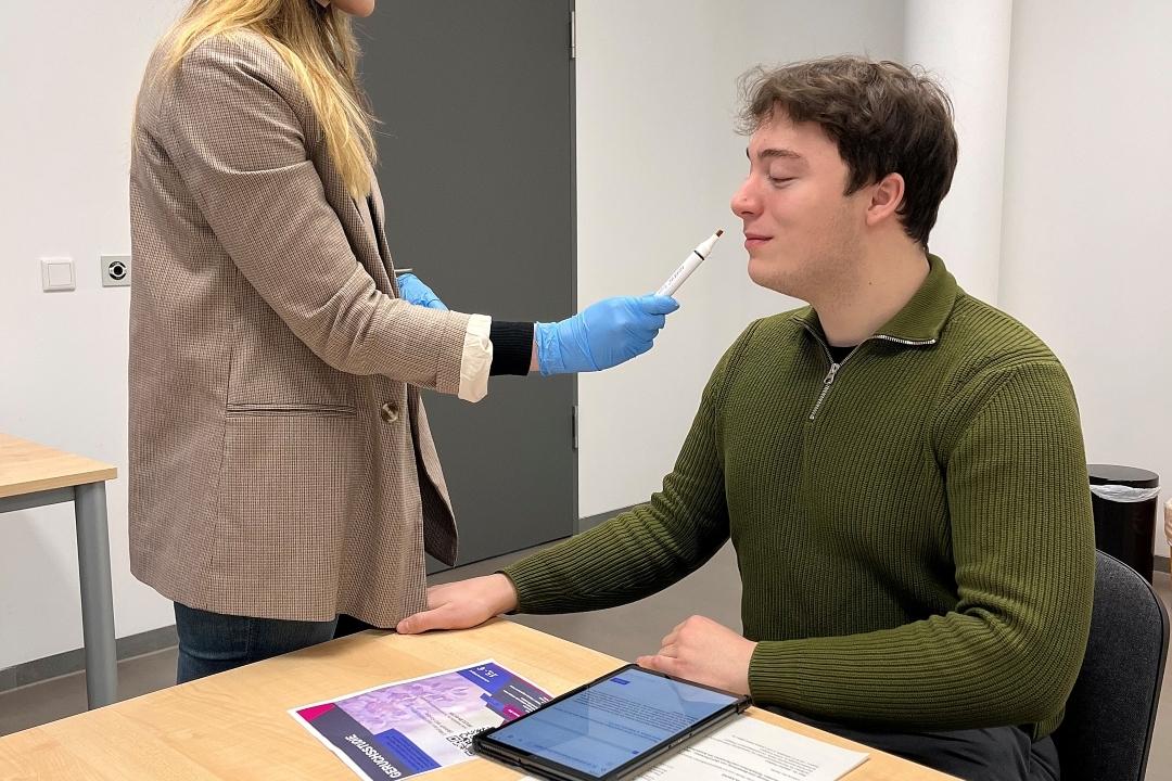 Neurosense-Geruchsstudie Ein Teilnehmer nimmt an der Neurosense-Geruchsstudie teil, während ihm eine Testleiterin eine Geruchsprobe präsentiert.