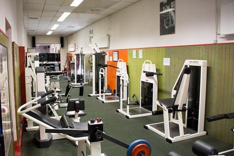 Blick auf verschiedene Fitnessger&auml;te im Kraftraum der Jahnhalle, aufgestellt entlang einer Wand.