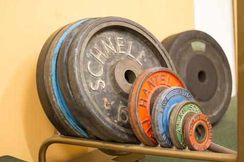 Mehrere Gewichtsscheiben in verschiedenen Größen auf einem Ablageständer.