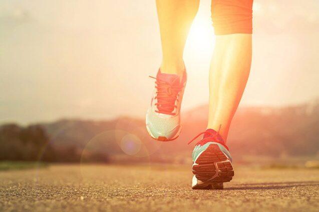 Generische Nahaufnahme  laufender Athletenfüße in Laufschuhen auf Asphalt