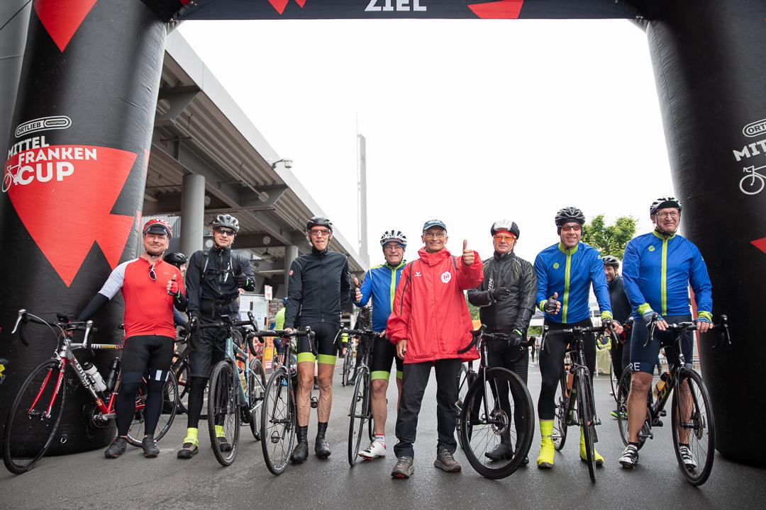 Gruppenfoto vieler Personen mit Rennrädern unter dem RTF-Startbogen