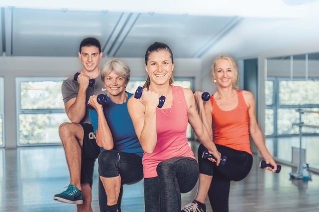 Eine Gruppe von Sportlerinnen und Sportlern sportlich aktiv im Sportkurs.